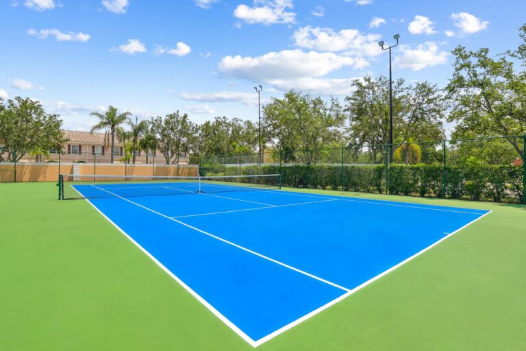 Expansive tennis court with trees in background